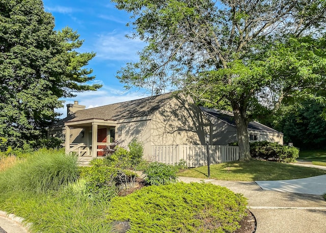 2204 Rivenoak Ct, Ann Arbor, MI 48103 - view of property exterior featuring a lawn, fence, a chimney, and roof with shingles