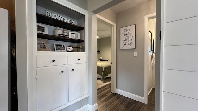 interior space featuring baseboards and dark wood-style flooring