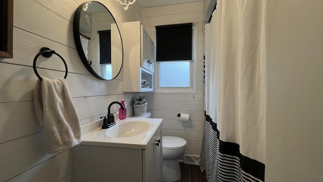 bathroom featuring vanity, wood finished floors, toilet, and curtained shower