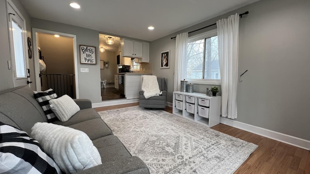 living room featuring recessed lighting, baseboards, and dark wood-style flooring