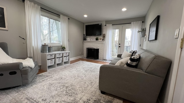 living room with recessed lighting, wood finished floors, a healthy amount of sunlight, and a fireplace