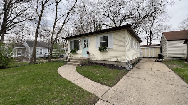 view of front of property featuring a storage unit, an outbuilding, driveway, and a front yard