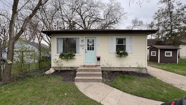 bungalow-style home with an outbuilding and a front yard