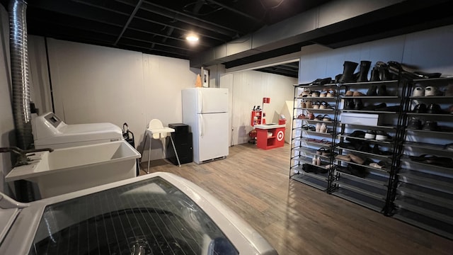 laundry area featuring laundry area, washer / dryer, a sink, and wood finished floors
