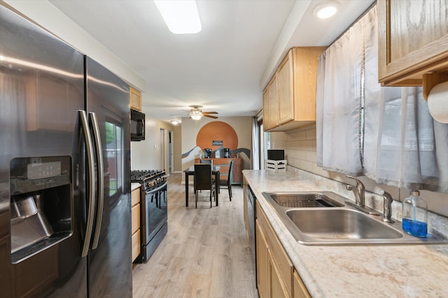kitchen featuring light brown cabinetry, appliances with stainless steel finishes, a sink, and light countertops