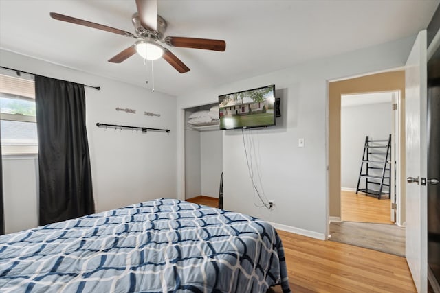bedroom featuring baseboards, ceiling fan, a closet, and light wood-style flooring