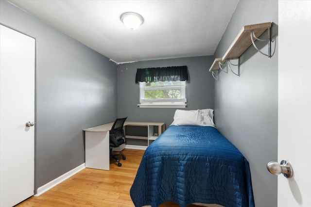 bedroom with baseboards and wood finished floors