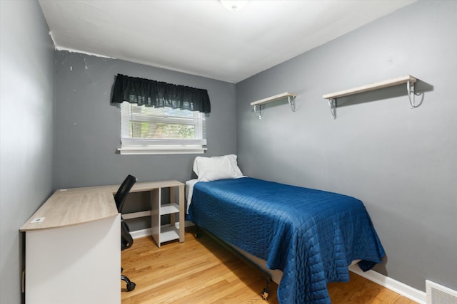 bedroom featuring visible vents and wood finished floors