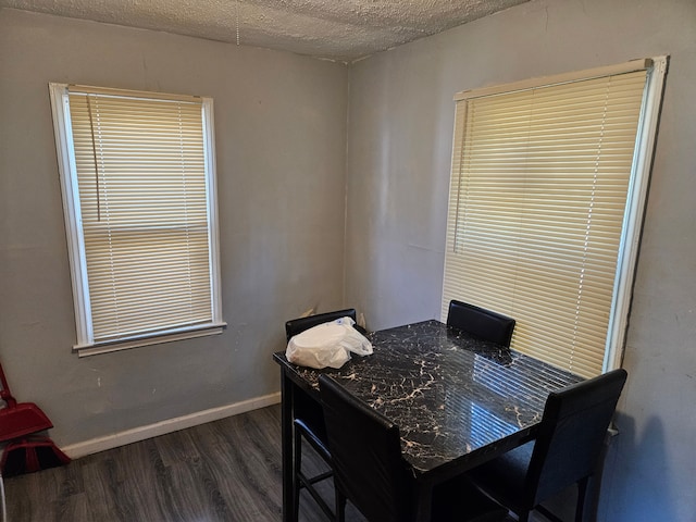 dining area with baseboards, a textured ceiling, and dark wood-style flooring