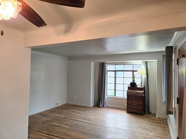 unfurnished room with visible vents, baseboards, ceiling fan, and wood finished floors
