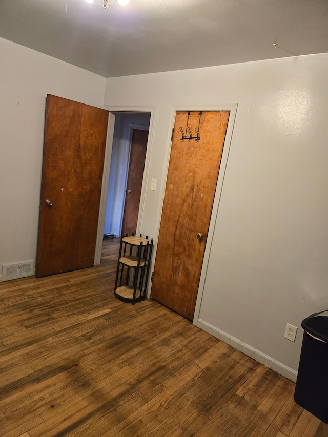 unfurnished room featuring visible vents, baseboards, and wood finished floors