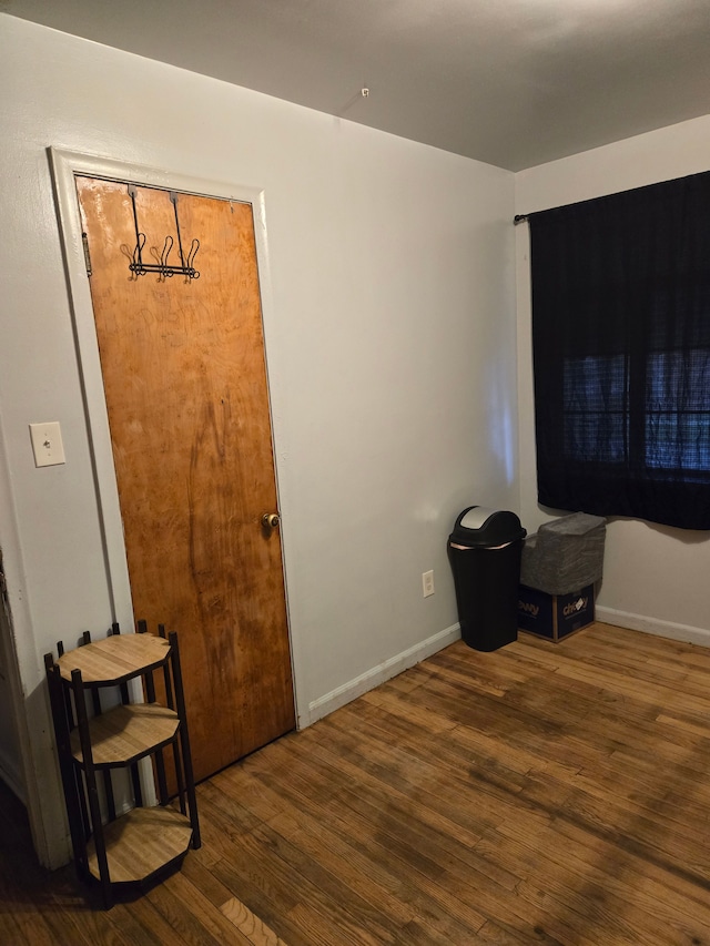 interior space featuring baseboards and wood finished floors
