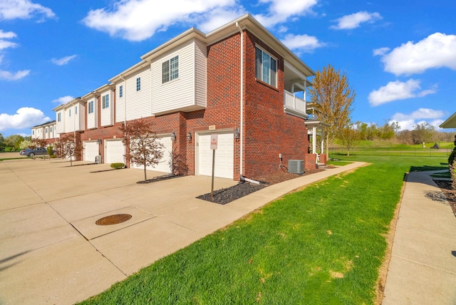 view of home's exterior with an attached garage, central air condition unit, driveway, and brick siding