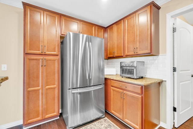 kitchen with freestanding refrigerator, dark wood finished floors, backsplash, and a toaster