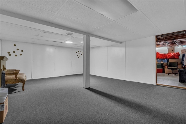 finished basement with carpet flooring and a drop ceiling