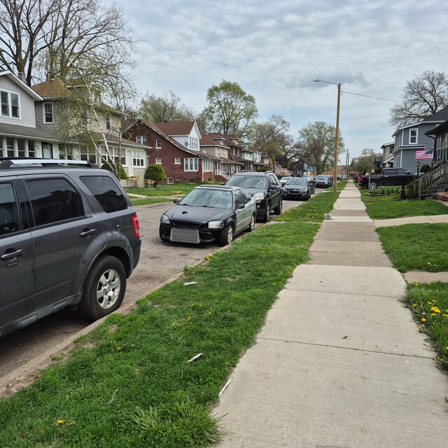 view of road with street lights, a residential view, and sidewalks