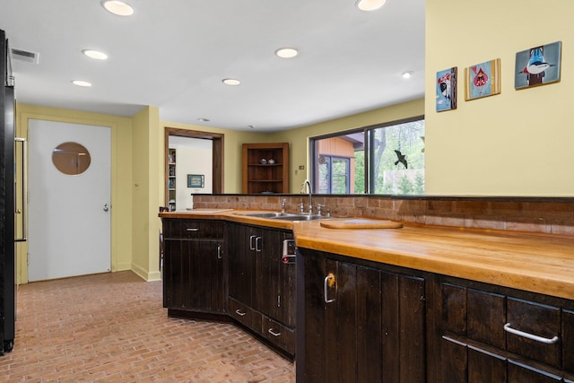 bathroom with brick floor, vanity, recessed lighting, decorative backsplash, and visible vents