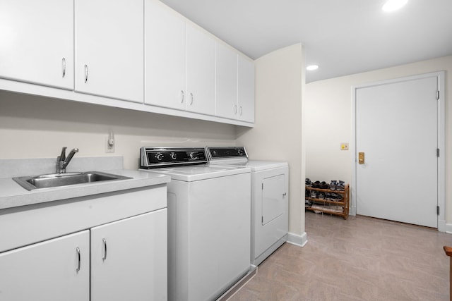 washroom featuring baseboards, recessed lighting, washer and clothes dryer, a sink, and cabinet space