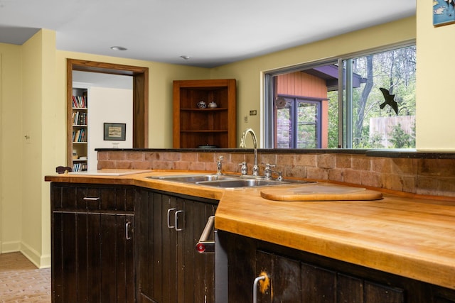 interior space featuring baseboards, a sink, and decorative backsplash