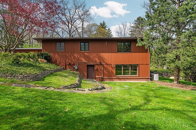 rear view of property featuring central AC unit and a yard