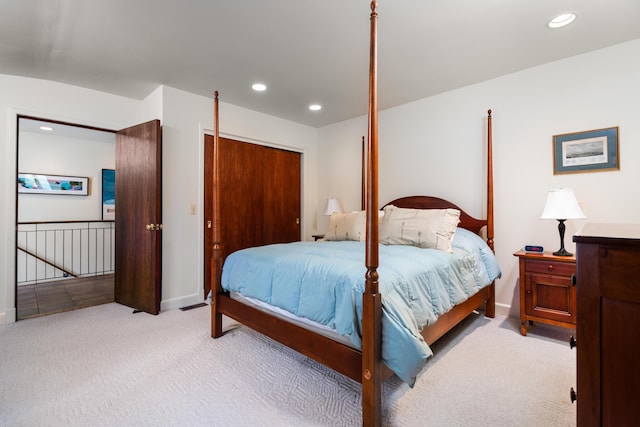 bedroom with baseboards, light carpet, a closet, and recessed lighting