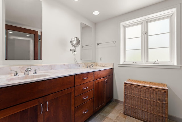 bathroom with a sink, baseboards, recessed lighting, and double vanity