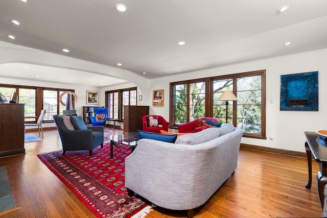 living area featuring wood-type flooring, arched walkways, and recessed lighting