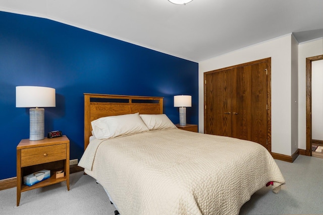 carpeted bedroom with baseboards and a closet