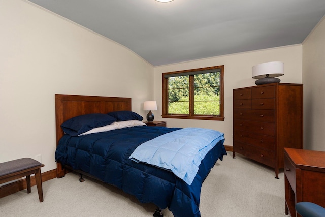 bedroom featuring baseboards, lofted ceiling, and light carpet