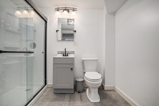 full bath featuring vanity, toilet, baseboards, and a stall shower