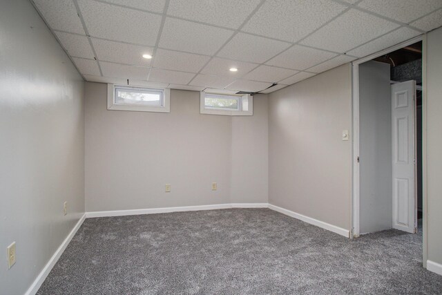 below grade area featuring carpet floors, recessed lighting, and a paneled ceiling