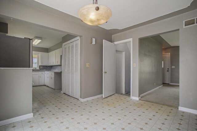 unfurnished dining area with baseboards, visible vents, and light floors