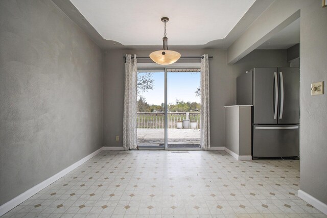 unfurnished dining area featuring baseboards and light floors