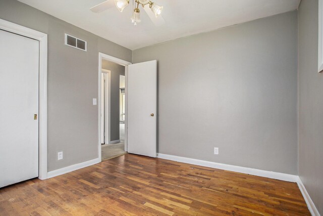 unfurnished bedroom featuring visible vents, baseboards, and wood finished floors
