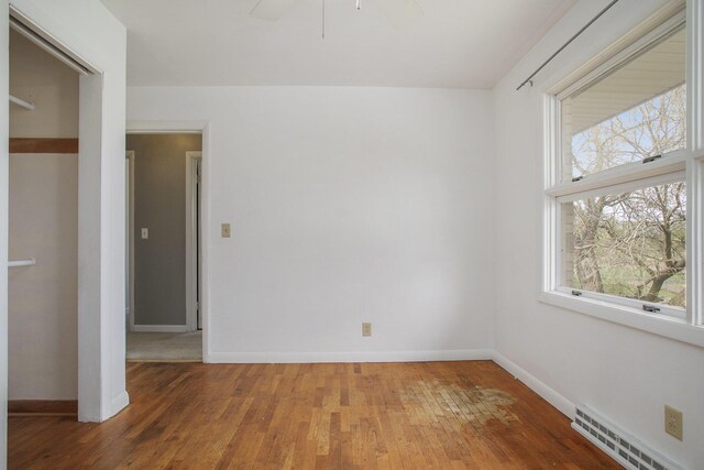 empty room featuring light wood-style floors, baseboards, and visible vents