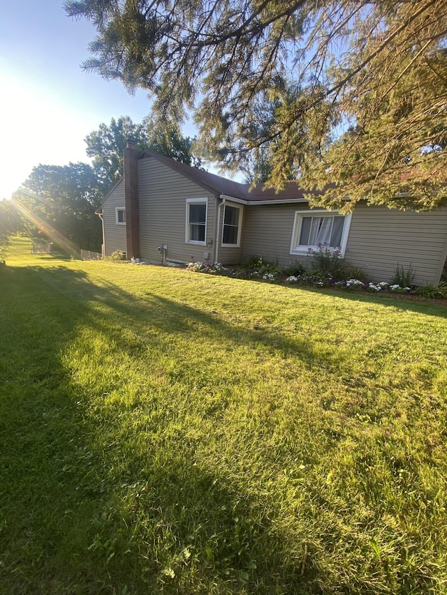 307 N Court St, Stanton, MI 48888 - rear view of property featuring a lawn and a chimney