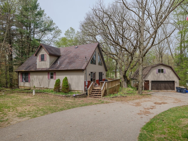 view of home's exterior featuring a deck, an outbuilding, and a garage