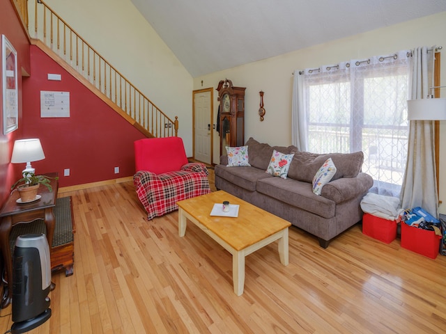 living room with stairs, lofted ceiling, and hardwood / wood-style flooring