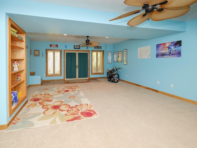 living area featuring baseboards, ceiling fan, and carpet flooring