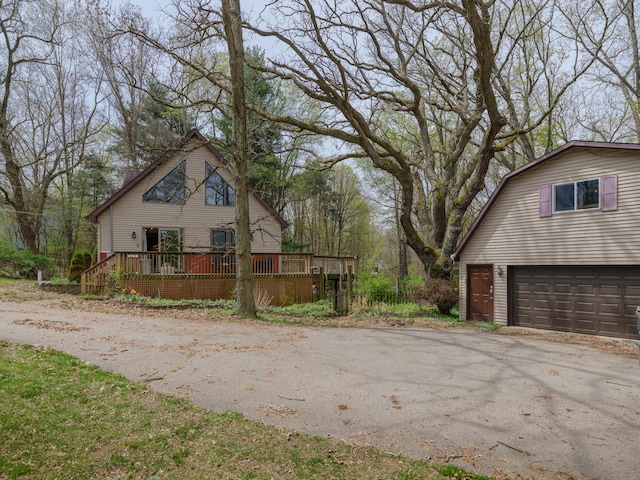 view of property exterior with a gambrel roof and a wooden deck