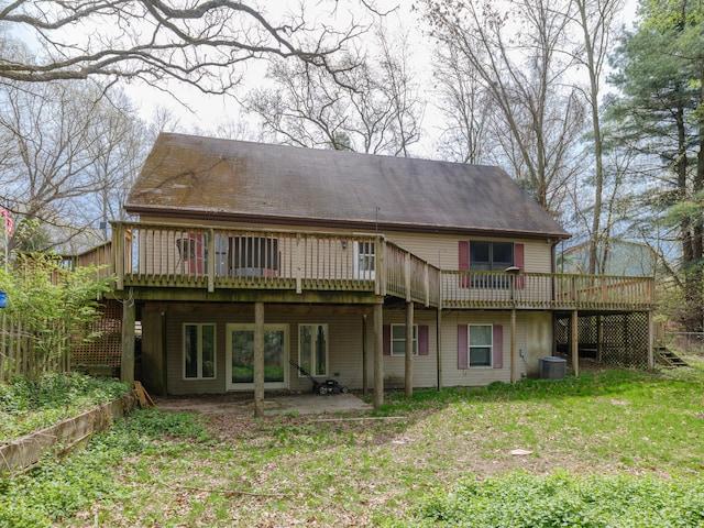 back of property featuring central AC unit, a wooden deck, and a yard
