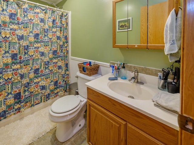 full bath featuring vanity, a wainscoted wall, toilet, and a shower with curtain