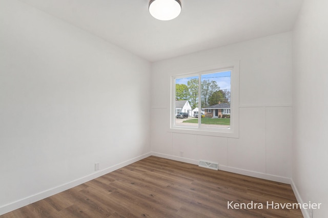 unfurnished room with visible vents, baseboards, and wood finished floors