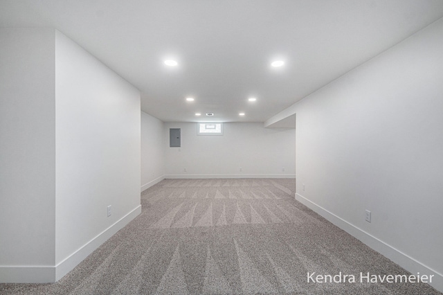 below grade area featuring recessed lighting, baseboards, light colored carpet, and electric panel
