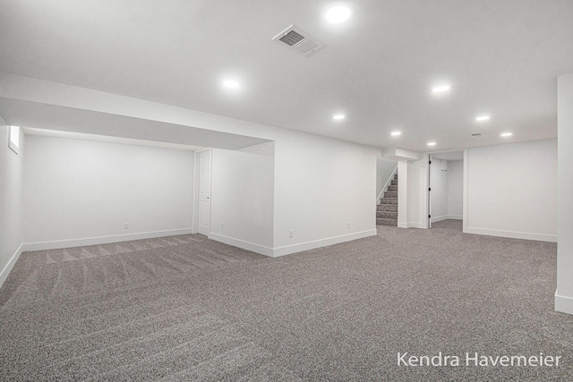 finished basement featuring baseboards, recessed lighting, stairs, and visible vents