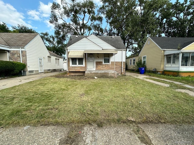 3577 S Bassett St, Detroit, MI 48217 - bungalow-style home featuring a front lawn, a shingled roof, brick siding, and board and batten siding