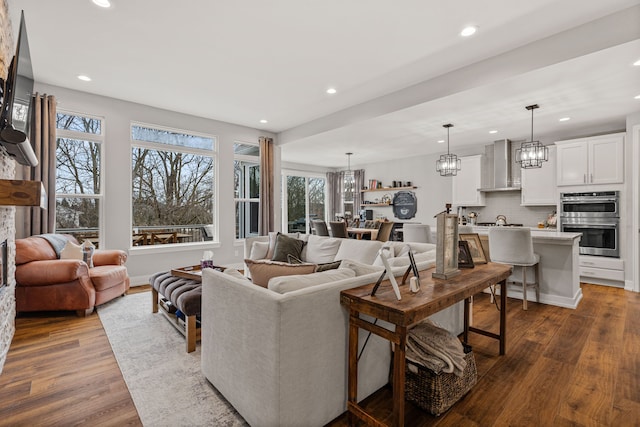living area with recessed lighting, dark wood-style flooring, and a notable chandelier