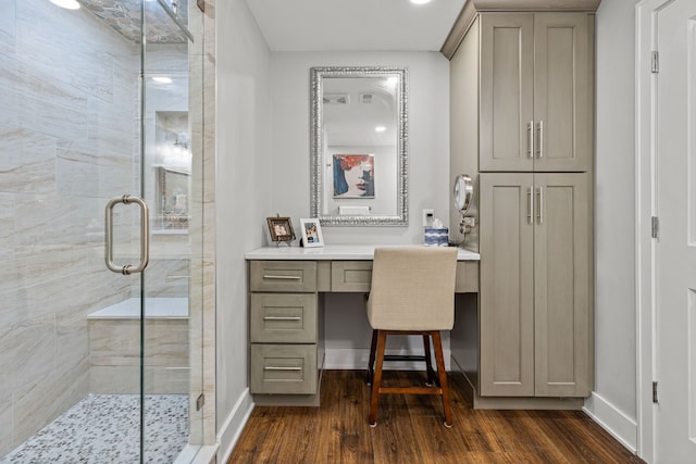 full bath featuring wood finished floors, baseboards, and a stall shower