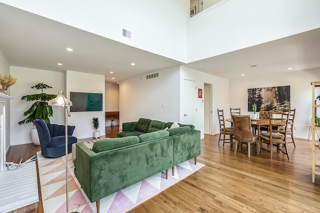 living room with recessed lighting, light wood finished floors, and visible vents