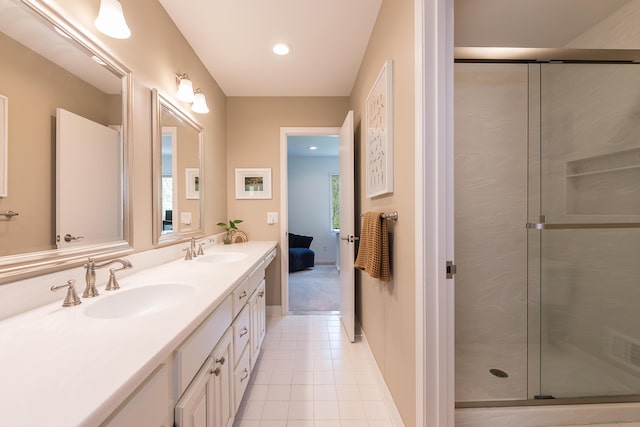 full bath featuring double vanity, tile patterned floors, a sink, and a stall shower